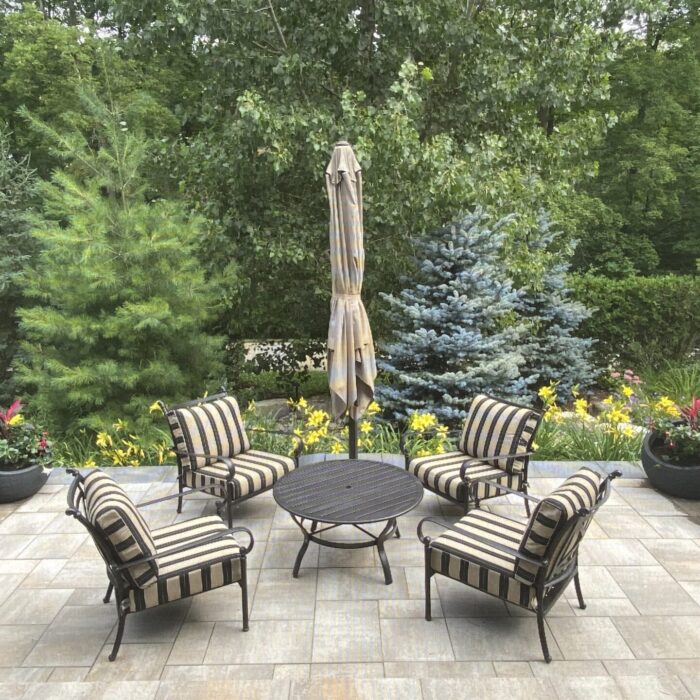 Outdoor raised paverstone patio with large slab stairs and engineered retaining walls